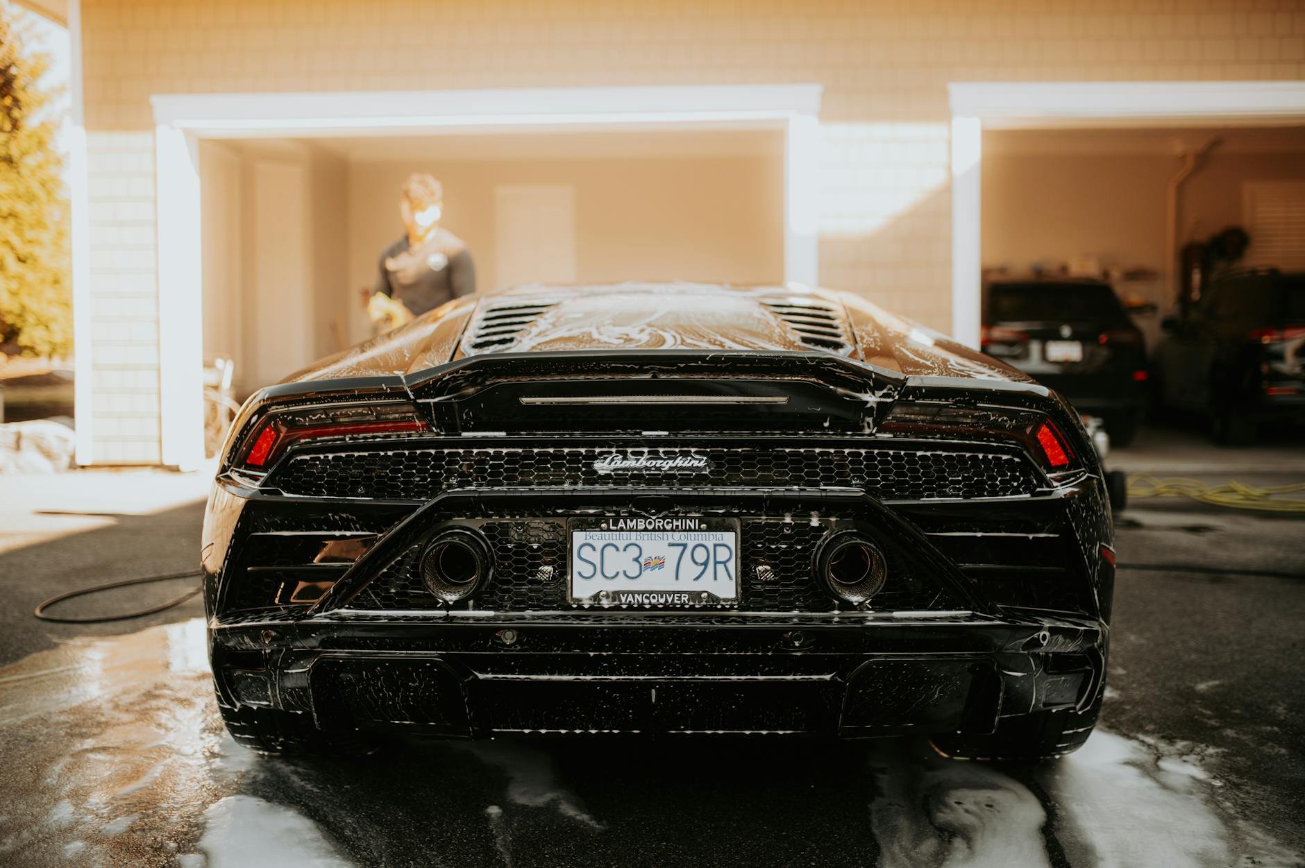 A concrete driveway being pressure washed, showing a clean versus dirty contrast